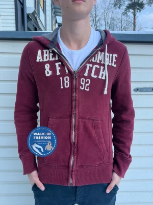 Abercrombie & Fitch ziphoodie - Tja! Säljer nu denna sjukt snygga ziphoodie ifrån abercrombie. Skick 8/10 slitet skick eftersom dne är vintage vilket bara gör dne snyggare. Modellen är 181 och väger 67kg. Hör av er vid funderingar!