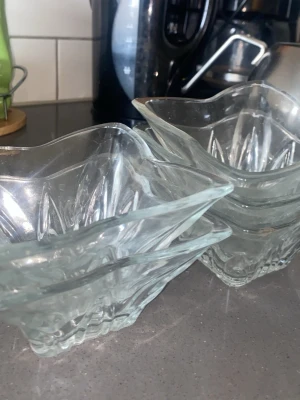 Fyra glasskålar i vågig form - Säljer fem genomskinliga glasskålar med vågig kant och dekorativt mönster i glaset. Perfekta för dessert eller snacks. Klassisk design som passar in i de flesta kök och ger en stilren känsla till serveringen.