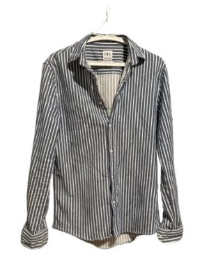 Randig skjorta från Zara Man - Snygg långärmad skjorta från Zara Man med vita och mörkblå ränder. Skjortan har klassisk krage, knäppning framtill och är tillverkad i bomull. Perfekt för en stilren och avslappnad look.