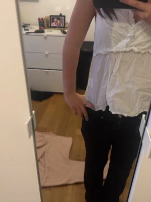 Vit ärmlös blus med omlottdetalj - Säljer en söt vit blus med omlottdetalj framtill. Toppen är ärmlös och har en luftig passform, perfekt för varmare dagar. Materialet känns lätt,passar till många olika outfits❤️