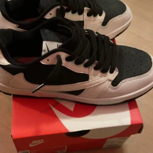 Travis Scott x Nike Dunk Low i svart och vitt. - Säljer ett par Travis Scott x Nike Dunk Low i svart och vitt. Skorna har den klassiska låga siluetten med svart tå och snörning, kombinerat med vita läderpaneler och en clean vit sula. Ett par eftertraktade “Cactus Jack”-sneakers som tar streetstyle till nästa nivå.  ✔️ Helt nya – aldrig använda ✔️ Originalkartong medföljer ✔️ Pris går att diskutera 💸  Perfekta för dig som vill sticka ut eller lägga till en exklusiv sneaker i samlingen.