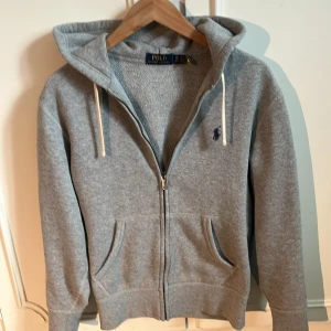 Grå zip hoodie från Polo Ralph Lauren - Grå zip hoodie zip från Polo Ralph Lauren.  Storleken är XS. Nypris 2300kr, tröjan är i mycket bra skit