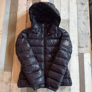Moncler navy blue pufferjacka - Säljer en navy blue pufferjacka från Moncler med klassisk logga på ärmen. Perfekt för kalla dagar och riktigt snygg streetstil. 
