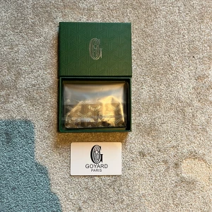 Mörkblå korthållare från G - Säljer ett stilrent svart kortfodral från G med deras ikoniska mönster i vitt och grått. Fodralet är tillverkat i exklusivt skinn och har flera fack för kort. Perfekt accessoar för dig som vill ha något både snyggt och praktiskt i fickan.