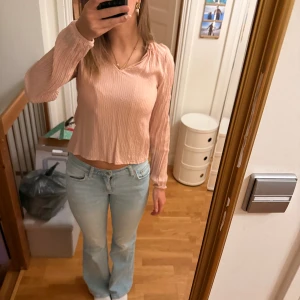 Ljusrosa ribbad långärmad blus - Säljer en ljusrosa långärmad topp. Toppen har en v-ringad hals och är perfekt för dig som gillar en enkel men söt stil.Säljer då jag ej tycker jag passar i den. Priset kan diskuteras.