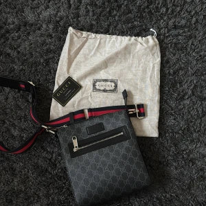 Svart axelväska från Gucci med GG-mönster - Snygg svart axelväska från Gucci med klassiskt GG-mönster över hela väskan.