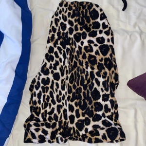 Leopardmönstrad topp - Säljer en snygg topp med leopardmönster i svart, beige och bruna toner. Toppen har en rak passform och är tillverkad i ett mjukt, stretchigt material som sitter skönt på kroppen. Perfekt för dig som vill sticka ut med en trendig look.