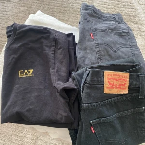 Svarta Levi's 501 jeans - Säljer två par svarta Levi's 512 jeans med klassisk röd etikett och läderpatch bak. Samt tröja i storlek M jeansen storlek S