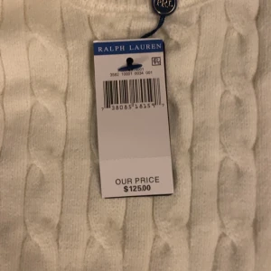 Vit kabelstickad tröja från Ralph Lauren - Kabelstickad vit tröja från Ralph Lauren med klassisk rund halsringning och broderad logga på bröstet.  Anledningen jag säljer tröjan är pågrund av för liten storlek på mig den är storlek S