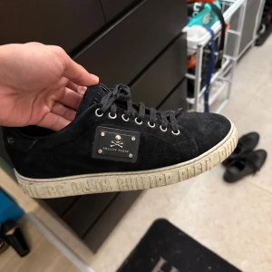 Svarta sneakers från Philipp Plein - Svarta sneakers från Philipp Plein i mocka med snörning och silverfärgade metalldetaljer. Köptes för runt 5lax för några år sen. Ganska stor i storleken så passar även 41, 42.