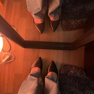 Svarta ballerinaskor med spetsig tå - Stilrena svarta ballerinaskor med spetsig tå och platt sula. Skorna har en klassisk form och är tillverkade i syntetmaterial med mjuk innersula i beige. Perfekta för en clean och elegant look.