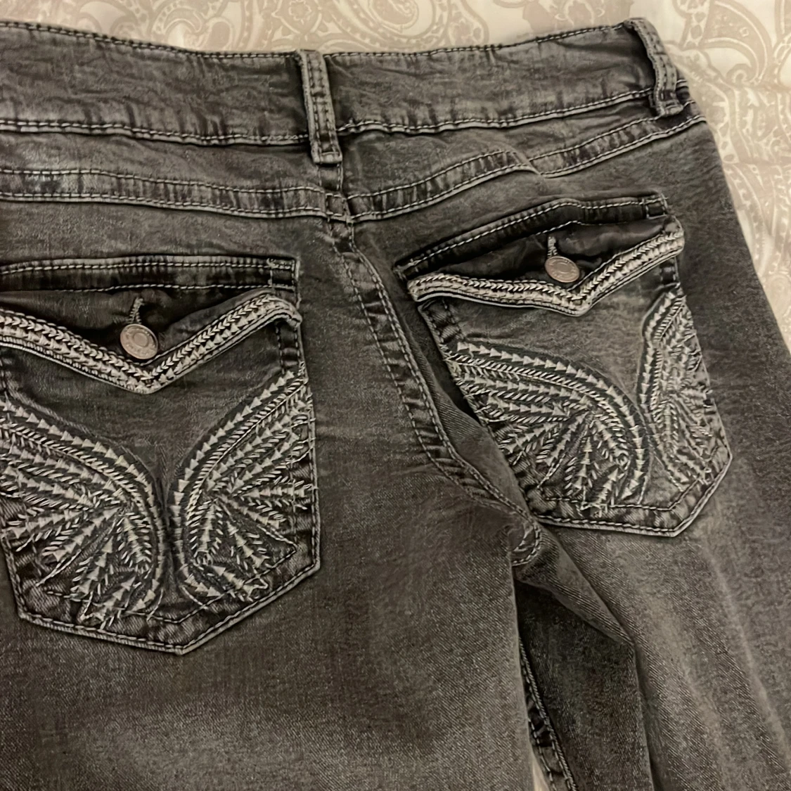Grå jeans med broderade bakfickor