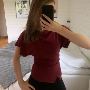 Vinröd asymmetrisk från Gina Tricot - Säljer en vinröd asymmetrisk topp från Gina Tricot med korta ärmar. Toppen har en lätt draperad effekt och asymmetrisk nederkant. Mjuk och stretchig i bomullsmix. Säljer då den inte kommer till användning! 💋om du undrar över något så fråga bara. 