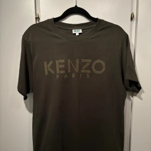 Kenzo T-shirt grön - Snygg grön t-shirt från Kenzo med logotryck framtill. Tillverkad i mjuk bomull. Bra skick! 100% bomull. Storlek Small.
