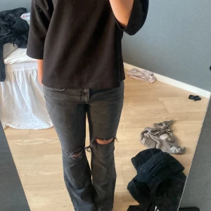 Svarta bootcut jeans med slitningar - (Innerbenslängd 81cm) (midjemått: 38-39cm)Säljer ett par svarta bootcut jeans med slitna detaljer vid knäna. Jeansen har klassisk femficksdesign och normal passform upptill.  Storlek S full lenght