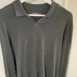 Mörkgrön tröja från dressmann - Säljer en stilren mörkgrön långärmad tröja från Dressmann i mjuk supima bomull. Tröjan har en klassisk krage och v-ringning, perfekt med en piké eller en skjorta under!