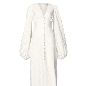 Vit Positano Dress från Adoore - En så fin klänning från Adoore i modellen ”Positano Dress” i färgen White. Så fin och bekväm klänning med fint mönster i storlek 34. Köpt för ca 1700kr. Endast använd ett fåtal gånger. Ps. två knappar har lossnat nertill💖