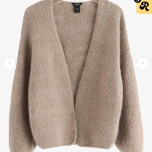 Beige stickad kofta från Lindex - Mysig beige stickad kofta från Lindex med oversized passform och långa ärmar. Koftan har en öppen front utan knappar och är tillverkad i ett fluffigt, mjukt material som känns riktigt skönt mot huden. Perfekt för lager-på-lager under kyliga dagar.