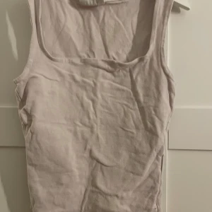 Ljusrosa linnetopp från Gina Tricot - Säljer en ljusrosa linnetopp från Gina Tricot, basically basics-kollektionen. Toppen är ärmlös med breda axelband och har en klassisk, rak skärning. Perfekt att matcha med jeans eller kjol för en enkel och clean look.