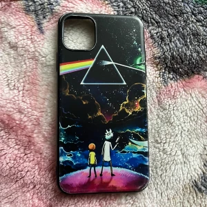 iPhone skal Rick and Morty x Pink Floyd - Unikt iPhone 11 Pro Max-skal med Rick and Morty och Pink Floyd Dark Side of the Moon-motiv. Skalet är i gott skick med mindre tecken på användning invändigt. Perfekt för fans av både serien och klassisk rock.