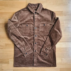 Brun manchester overshirt från Sisley - Säljer en brun overshirt från Sisley i mjuk manchester med klassisk krage och två stora bröstfickor med knappar. Bra skick!