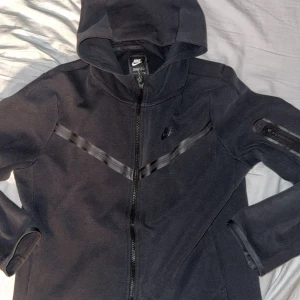 Svart Nike tech hoodie XL i barnstolek - Nike tech fleece svart, storlek XL i barnstorlek. Motsvarar S i vuxenstorlek! Blivit för kort för mig 