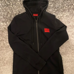 Svart hugo boss zip up - Hej, säljer en svart hugo boss zip up. Äkta.  storlek XS som är True to Size. Riktigt skön. Perfekt till vintern/hösten och som aldrig är använd och säljer vid bästa priset. Fraktar snabbt så hör av er. Nypris zalando: 1099kr 