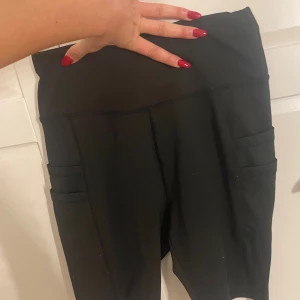Svarta shorts med fickor - Svarta shorts med praktiska sidofickor. Snygg och enkel design som sitter tight och är perfekta för träning eller chill. Materialet är stretchigt som ger bra rörelsefrihet och komfort.