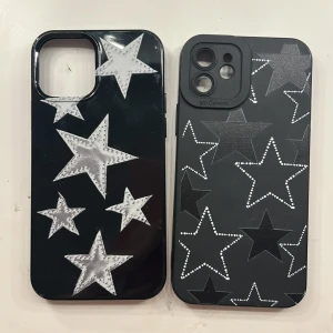 Stjärnmönstrade mobilskal för iPhone - Två snygga mobilskal med stjärnmönster, passar iPhone-12 med större kameralins. Ett skal är blankt med vita stjärnor, det andra matt med prickade och blanka stjärnor. Mindre repor och bruksspår syns, men båda är i gott skick och skyddar din mobil med stil. De koster 20kr tsm
