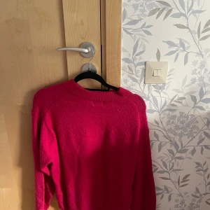 Rosa stickad tröja med rund hals - Snygg rosa stickad tröja med rundad hals och långa ärmar. Perfekt för dig som gillar färg och vill ha något mjukt och bekvämt. 