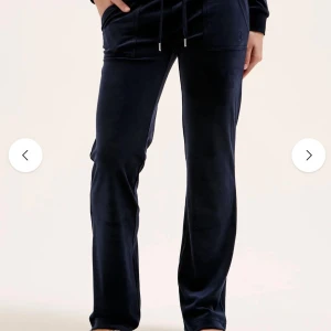 Juicy byxor  - Mörkblå mjukisbyxor från Juicy Couture i mjuk sammet med raka ben, snörning i midjan och fickor med logga och snygga knappar bak. 🥰
