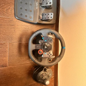 Logitech G29 Driving Force Racing Wheel & Pedals - Logitech G29 ratt, pedaler och växelspak för PlayStation och PC. Realistisk force feedback, slitstark läderklädsel och robusta metallpedaler. Växelspak ingår. Mycket fint skick, endast lättare bruksspår på pedalerna.