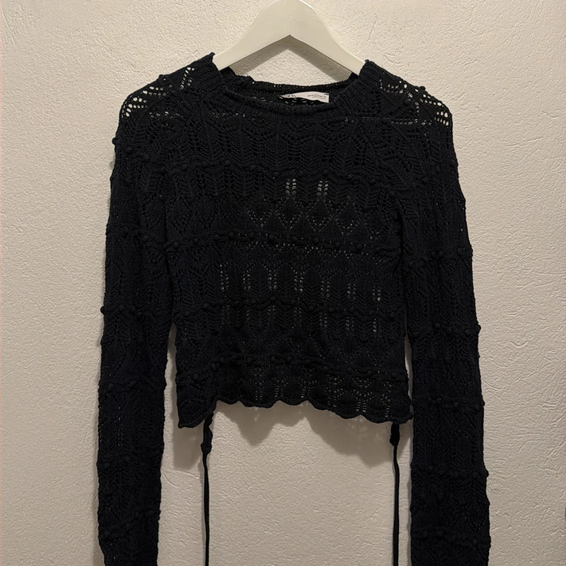 Svart stickad bolerotopp med snörning