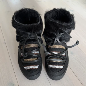 Svarta Inuikii vinterskor med päls  - Säljer dessa unika Inuikii vinterskor med en unik design. Skorna är i väldigt fint skick. 