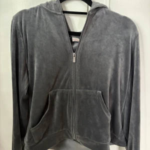 Grå velour hoodie från Gina Tricot - Mjuk och skön grå hoodie i velour från Gina Tricot. Tröjan har huva, dragkedja framtill och två stora fickor. Använd men i bra skick 
