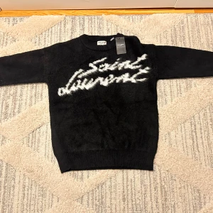 Svart Saint Laurent stickad tröja - Svart stickad tröja från Saint Laurent med vit, helt ny och kommer med påsen och etikett 