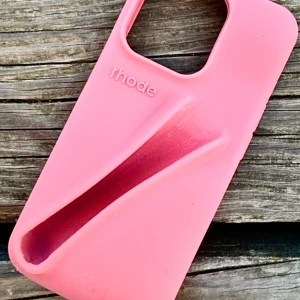Lip-case "Toast" från Rhode till IPhone! - Mjukt silikonskal "Toast" från Rhode som passar IPhone 13/14/15 & deras PRO-modeller med plats för ditt favoritlipgloss. Nytt och oanvänt. 