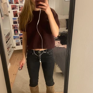 Vinröd stickad tröja   - Säljer en vinröd croppad stickad tröja från Gina Tricot med korta ärmar och rund hals. Tröjan har en loose passform och är gjord i ett mjukt stickat material som känns skönt mot huden. Perfekt för dig som gillar en chill och trendig stil.