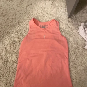 Rosa linnetopp från RS Sports - Säljer en sportig rosa linnetopp från RS Sports i storlek 10/12Y. Toppen är ärmlös och har rund halsringning. Materialet är lätt och syntetiskt med meshstruktur som andas, perfekt för träning. Diskret logga framtill i vitt.