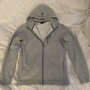 Grå Sail Racing hoodie - Grå zip-up hoodie från sailracing i storlek 176, köpt på kids brandstore. Knappt använd, skriv om du har frågor 