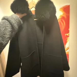 Svart kappa med päls - Säljer denna kappan i strl S. Ser som ny ut. Nypris 2500/3000. Glömt vad hemsidan hette