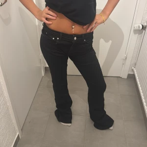 Svarta bootcut jeans från g perfect jeans Gina - Svarta jeans från g perfect jeans i storlek 36. Modellen har låg midja och bootcut-ben, vilket ger en snygg siluett. Klassisk femficksdesign och stretchigt jeanstyg för skön passform. Perfekta för dig som gillar en tidlös look med lite edge.