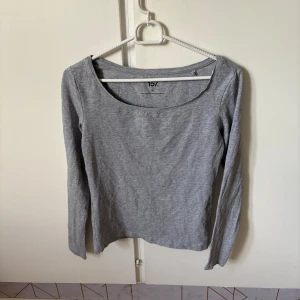 Grå långärmad topp från Lager 157 - En basic grå långärmad topp från 157 med rund halsringning. Tillverkad i en mjuk bomullsblandning med lite stretch för en bekväm passform. Perfekt att styla med jeans eller kjol för en enkel och clean look.