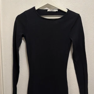 Svart långärmad klänning  - En snygg svart långklänning med långa ärma och med öppen rygg. Passformen är tight och materialet är ”finstickat”. Använd fåtal ggr 💕