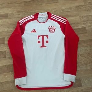 Bayern München Kimmich långärmad XS - Säljer en officiell Bayern München fotbollströja med Kimmich och nummer 6 på ryggen. Tröjan är långärmad, vit med röda ärmar och detaljer, samt Adidas logga och klassiska ränder på armarna. Tröjan är den säsongen 23/24.