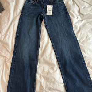 Wide leg jeans Low waist från Zara, blå, stl 34 - Snygga blå jeans från Zara i modellen wide leg. Klassisk femficksdesign, låg midja och raka, vida ben. Jeansen är tillverkade i bomull och har en mörkblå tvätt med subtila slitningar. Helt nya med prislapp kvar! Säljer pga av att jag köpte fel storlek, behöver bli av med dem!💙