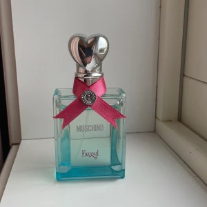 Moschino Funny! Perfume - MOSCHINO FUNNY! EN HÄRLIG DOFT SOM KOMBINERAR MOUSSLANDE FRUKTIGHETSNOTER MED ETT BLOMMIGT HJÄRTA. FRÄSCHHETEN AV BITTERAPELSIN OCH ROSA PEPPAR MÖTER MJUKHETEN AV JASMIN OCH PION OCH SKAPAR EN OEMOTSTÅNDLIG KONTRAST.