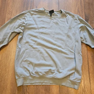Ljusgrå sweatshirt från H&M - En enkel och stilren ljusgrå sweatshirt från H&M i relaxed fit. Tröjan har rund hals, långa ärmar och ribbade muddar vid ärmslut och nederkant. Perfekt för chill dagar och passar till det mesta. Materialet är mjuk bomull för skön komfort.