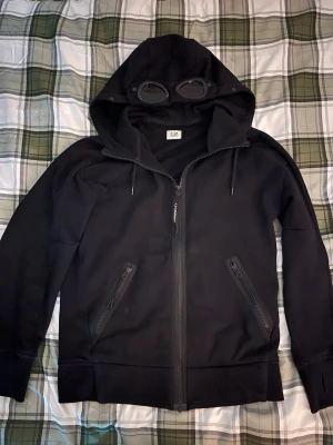 Cp company zip hoodie - Svart cp company zip hoodie i storlek xs och det finns två små fläckar vid fickorna men kan tvättas bort enkelt. Pris går att diskuteras