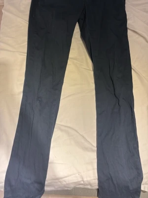 Mörkblå byxor från Dondup, storlek 28 - Snygga mörkblå byxor från Dondup, tillverkade i Italien. De har en rak passform och är gjorda i ett mjukt bomullsmaterial som känns skönt mot huden. Perfekta för dig som gillar stilrena och klassiska plagg med italiensk touch.